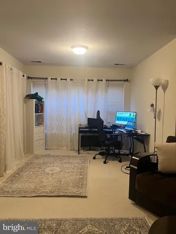 a living room with furniture a air conditioner vent and a rug