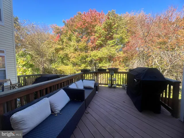 a balcony with wooden floor and outdoor seating