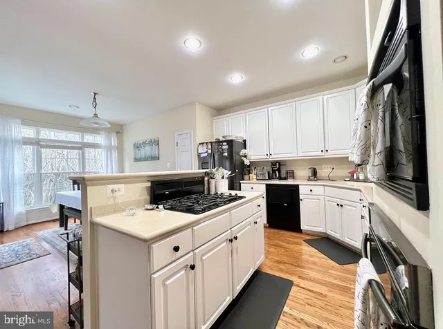 a kitchen with white cabinets sink and appliances