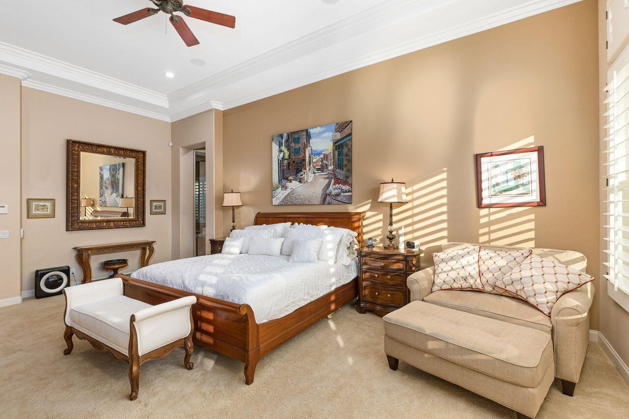 20 Vista Encantada Rancho Mirage, CA 92270 - Photo 18 of 37 a spacious bedroom with a bed a couch and a chandelier