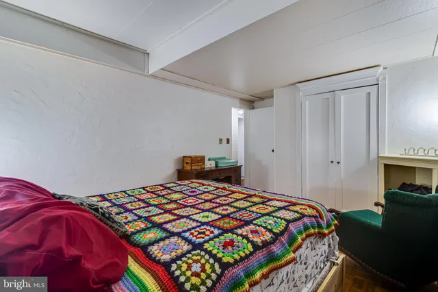 a bedroom with a bed and a view of kitchen