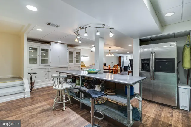 a room with stainless steel appliances lots of wooden furniture