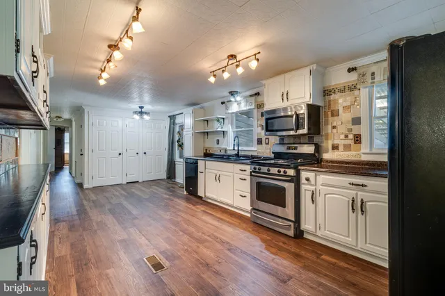 a kitchen with stainless steel appliances a refrigerator sink and cabinets