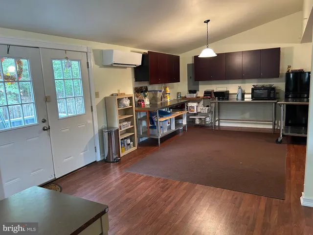 a kitchen with stainless steel appliances wooden floors and view living room
