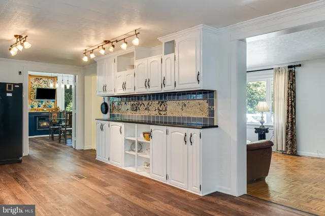 a kitchen with stainless steel appliances granite countertop a refrigerator sink and white cabinets