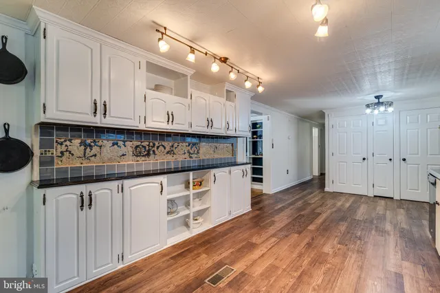 a kitchen with granite countertop white cabinets and black appliances