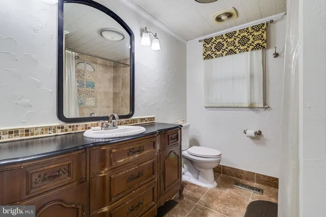 a bathroom with a toilet sink and mirror