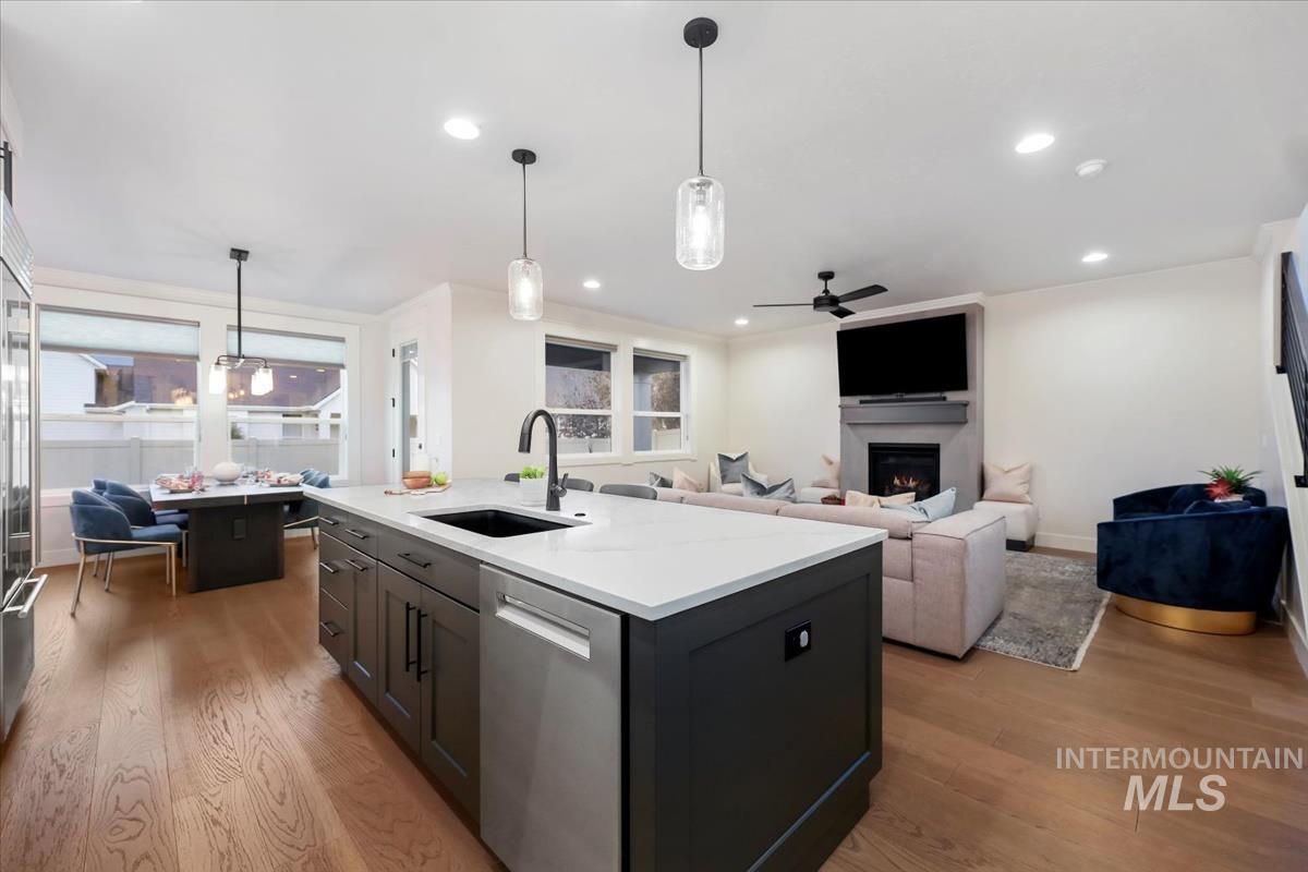 4705 North Morpheus Place Meridian, ID 83646 - Photo 14 of 45 Kitchen with light wood finished floors, hanging light fixtures, stainless steel appliances, a ceiling fan, and a center island with sink