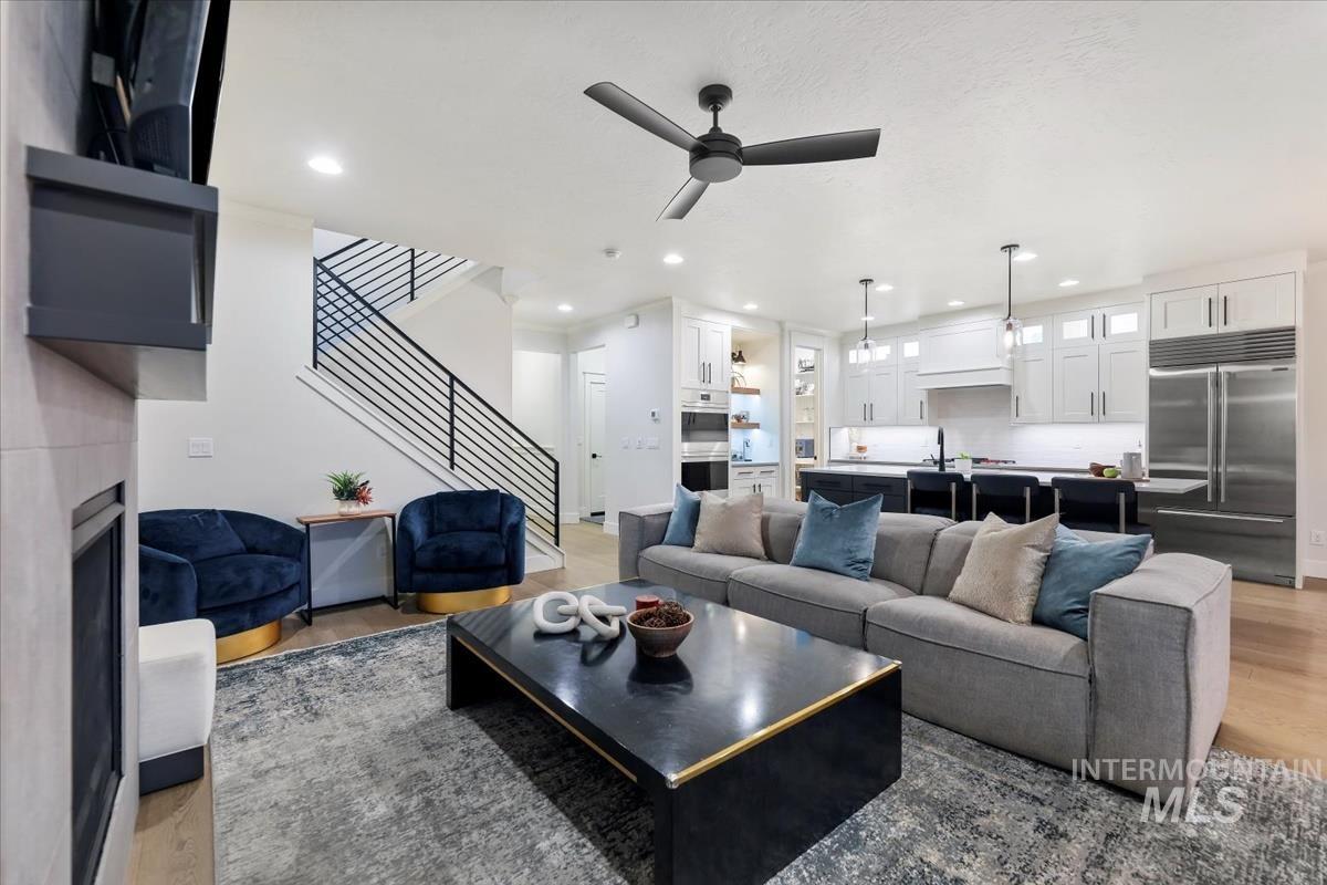 4705 North Morpheus Place Meridian, ID 83646 - Photo 18 of 45 Living area with light wood-style flooring, ceiling fan, stairs, recessed lighting, and a fireplace