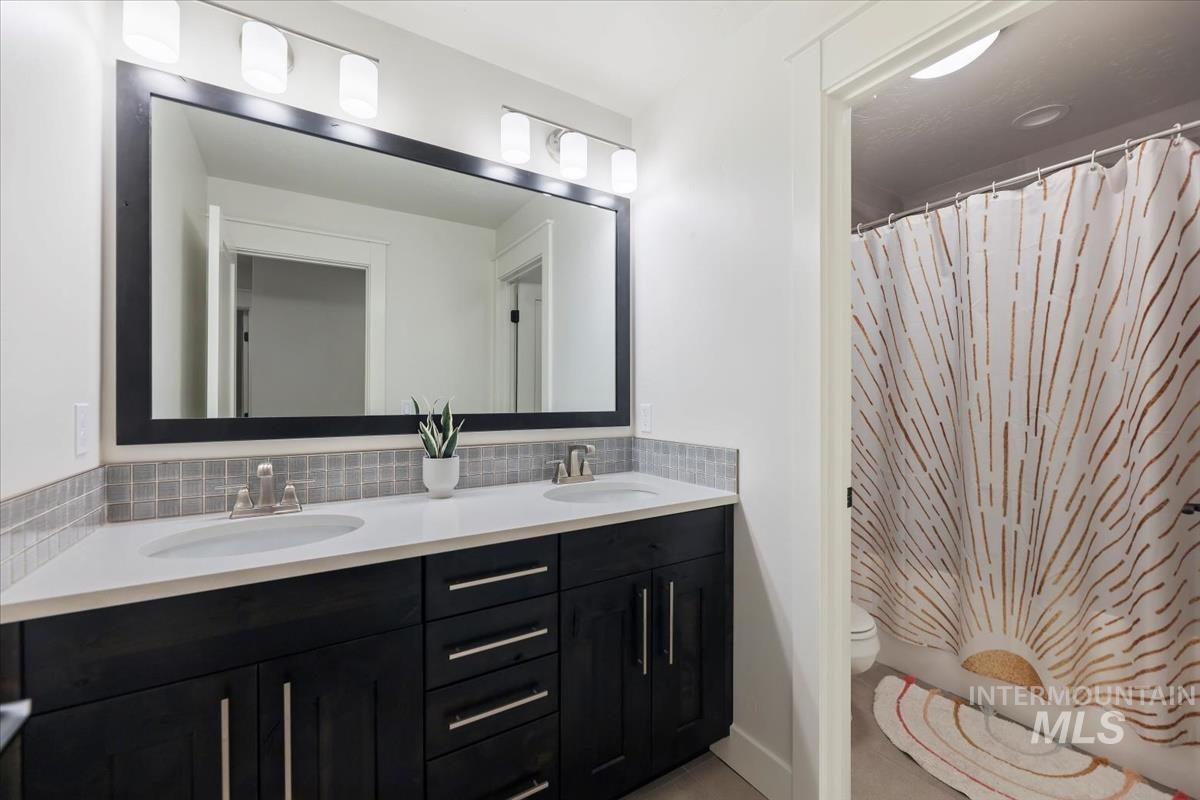 4705 North Morpheus Place Meridian, ID 83646 - Photo 34 of 45 Bathroom featuring double vanity, tasteful backsplash, and shower / bath combo