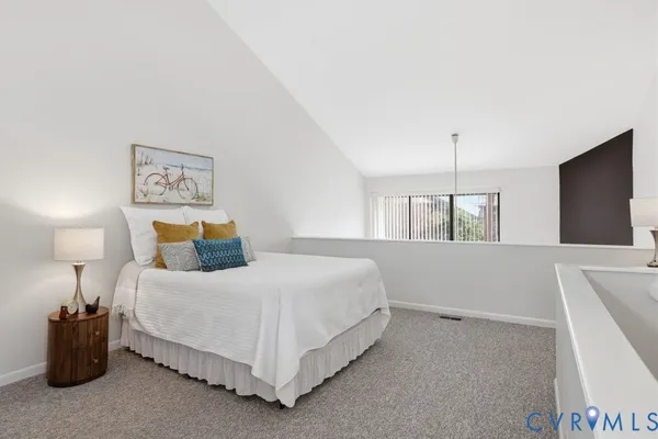 a bed sitting in a bedroom and a lamp