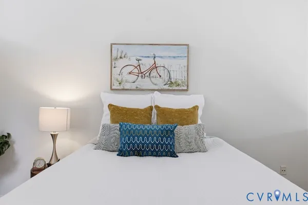 a bedroom with a bed and a painting on the wall