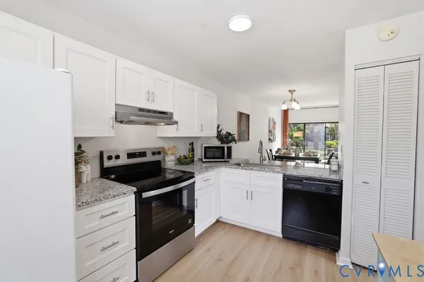 a kitchen with white cabinets and stainless steel appliances