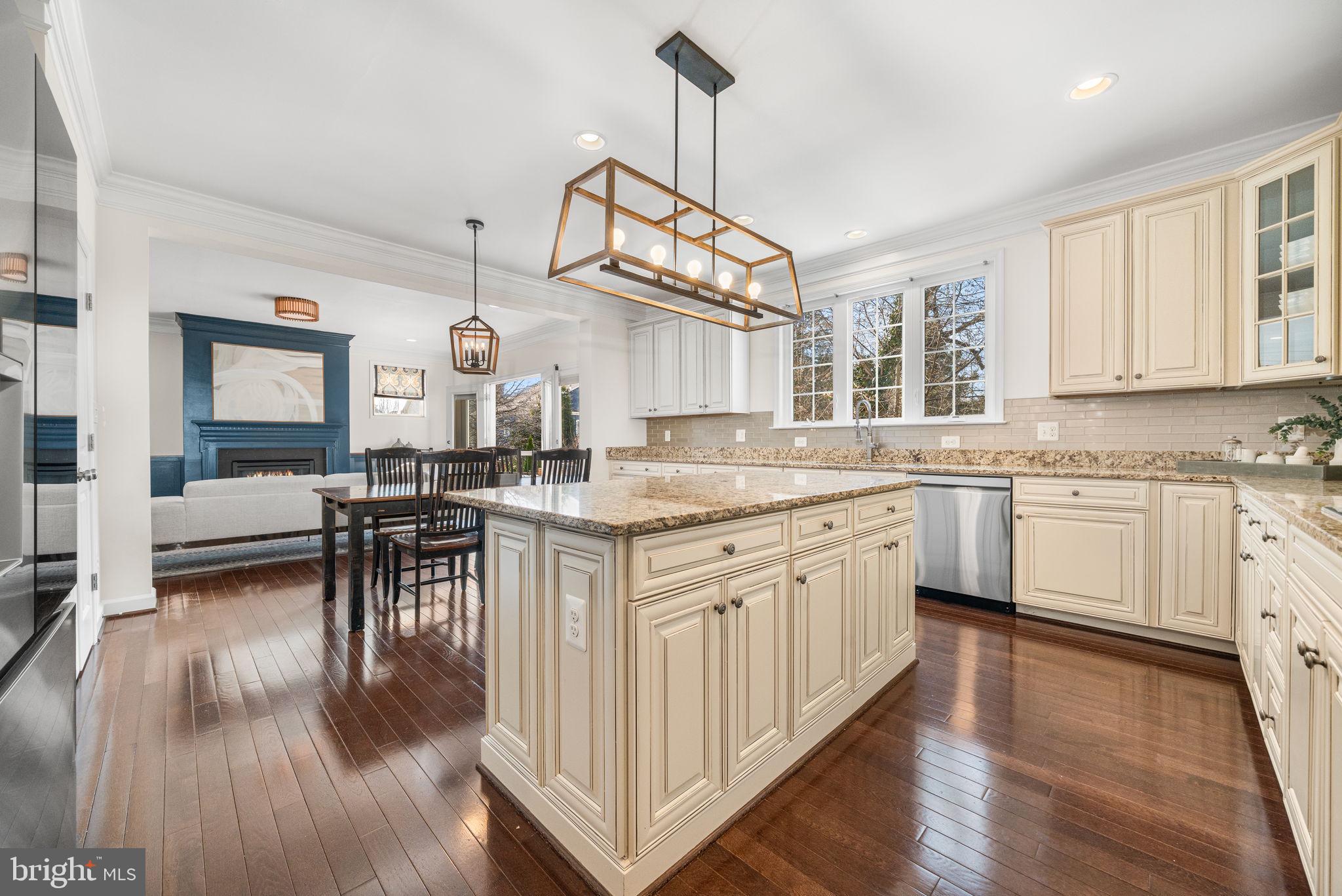 8032 Washington Road Alexandria, VA 22308 - Photo 22 of 50 a kitchen with granite countertop a stove a sink dishwasher a dining table and chairs with wooden floor