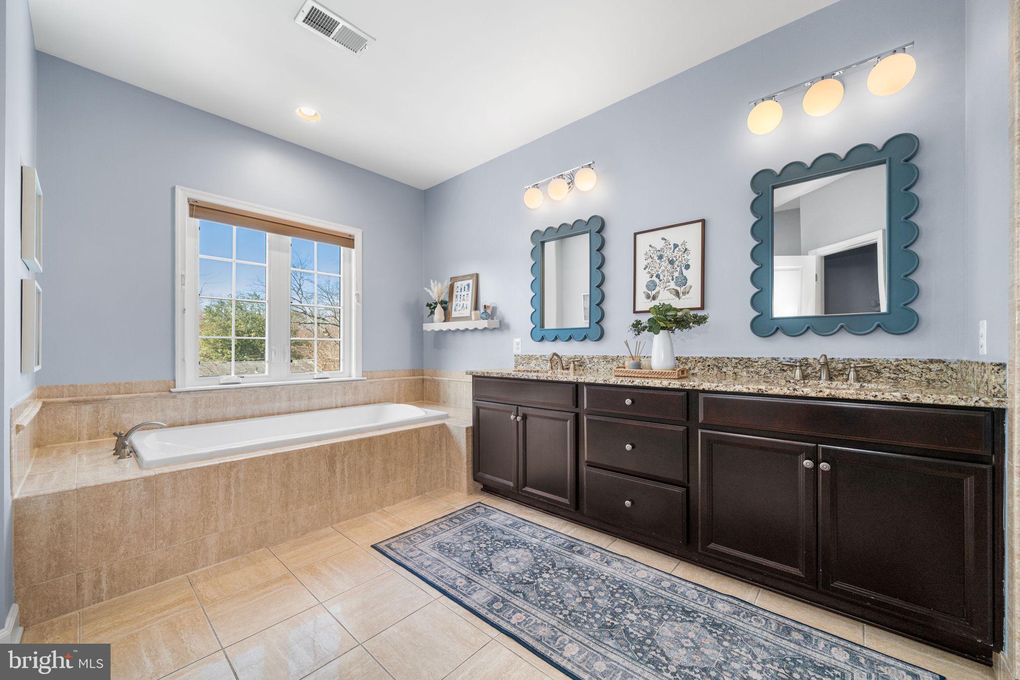 8032 Washington Road Alexandria, VA 22308 - Photo 31 of 50 a spacious bathroom with a granite countertop tub sink and mirror