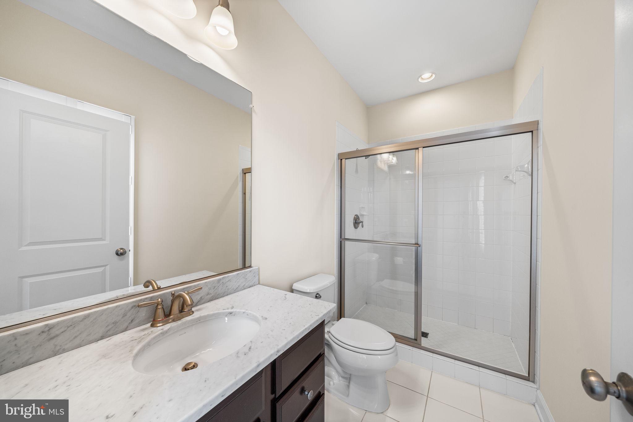 8032 Washington Road Alexandria, VA 22308 - Photo 38 of 50 a bathroom with a granite countertop sink toilet and shower