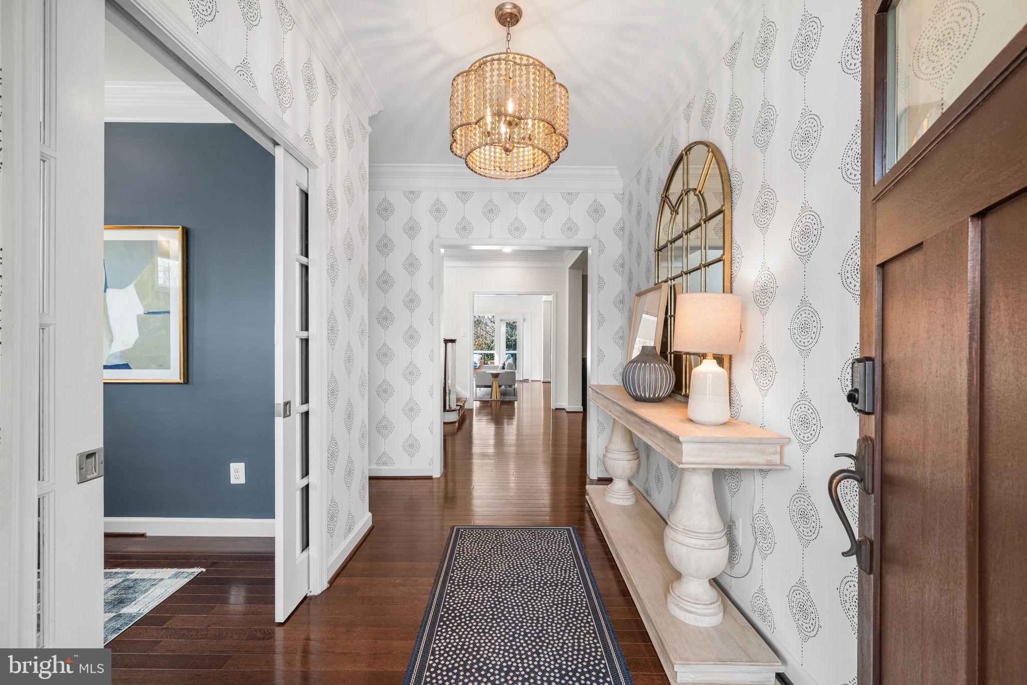 8032 Washington Road Alexandria, VA 22308 - Photo 7 of 50 a hallway with painting on the wall and a wooden floor