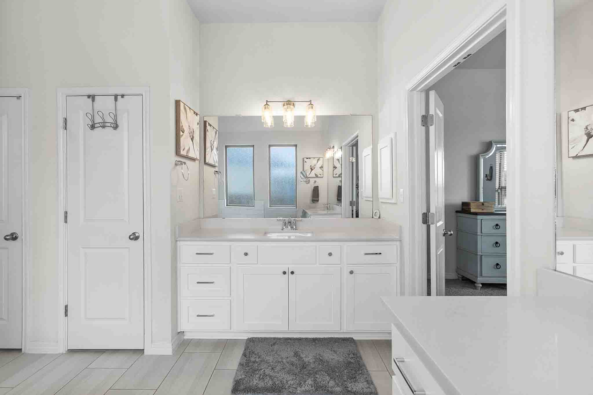 166 West Branch Road Kyle, TX 78640 - Photo 18 of 39 White cabinetry, clean lines, and a spacious vanity create a tranquil and well-appointed primary bathroom.