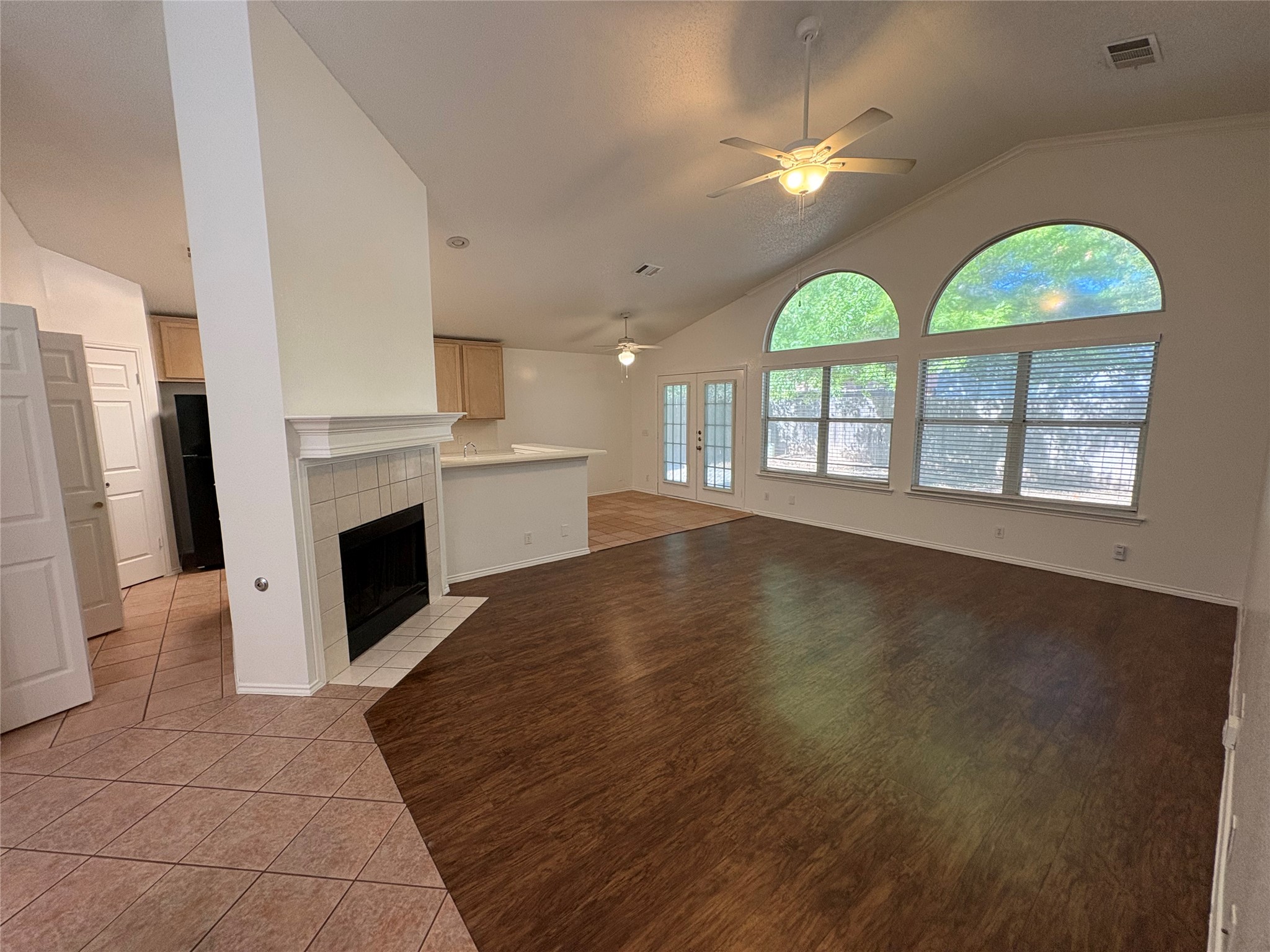 Living room with ceiling fan, fireplace, view of back yard and open to formal dining, breakfast area and kitchen