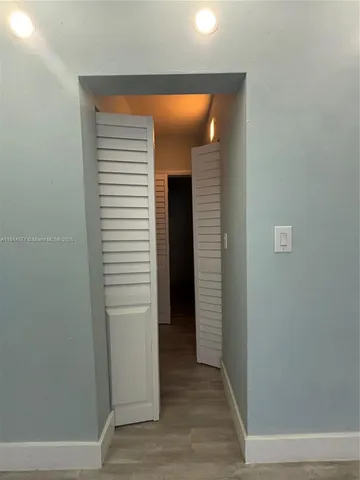 a view of a hallway with wooden floor