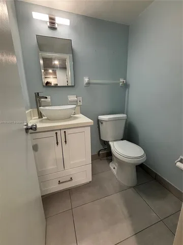 a white toilet sitting next to a bathroom sink