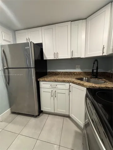 a kitchen with a refrigerator and a sink