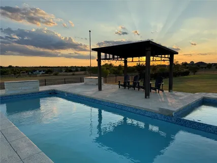 a roof deck with table and chairs under an umbrella