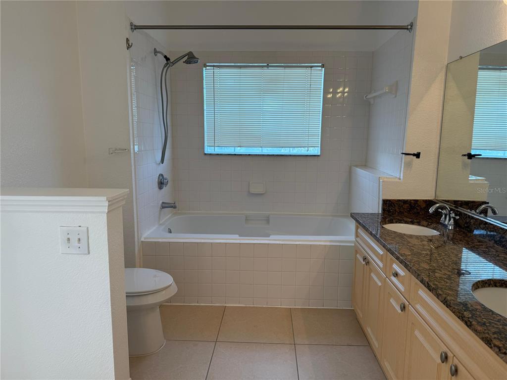 3707 Conroy Road, Unit 1731 Orlando, FL 32839 - Photo 19 of 40 a bathroom with a granite countertop sink a toilet and bathtub