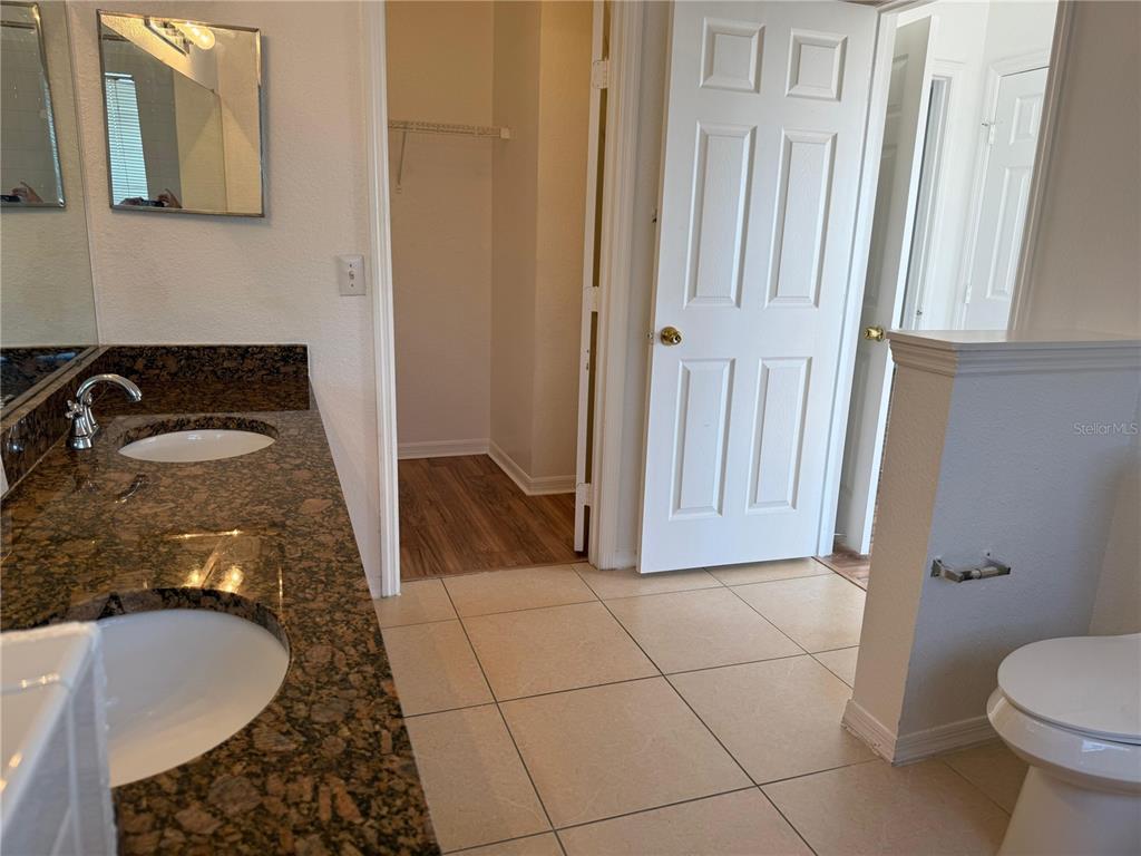 3707 Conroy Road, Unit 1731 Orlando, FL 32839 - Photo 20 of 40 a bathroom with a granite countertop sink and a mirror