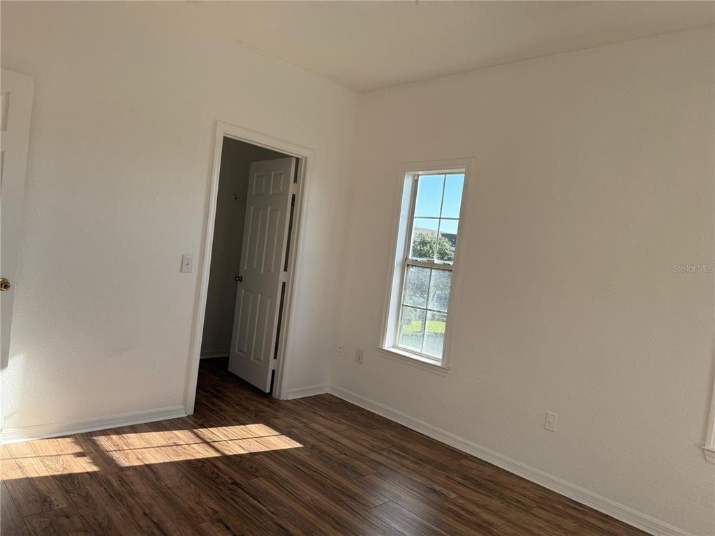 3707 Conroy Road, Unit 1731 Orlando, FL 32839 - Photo 25 of 40 an empty room with wooden floor and windows
