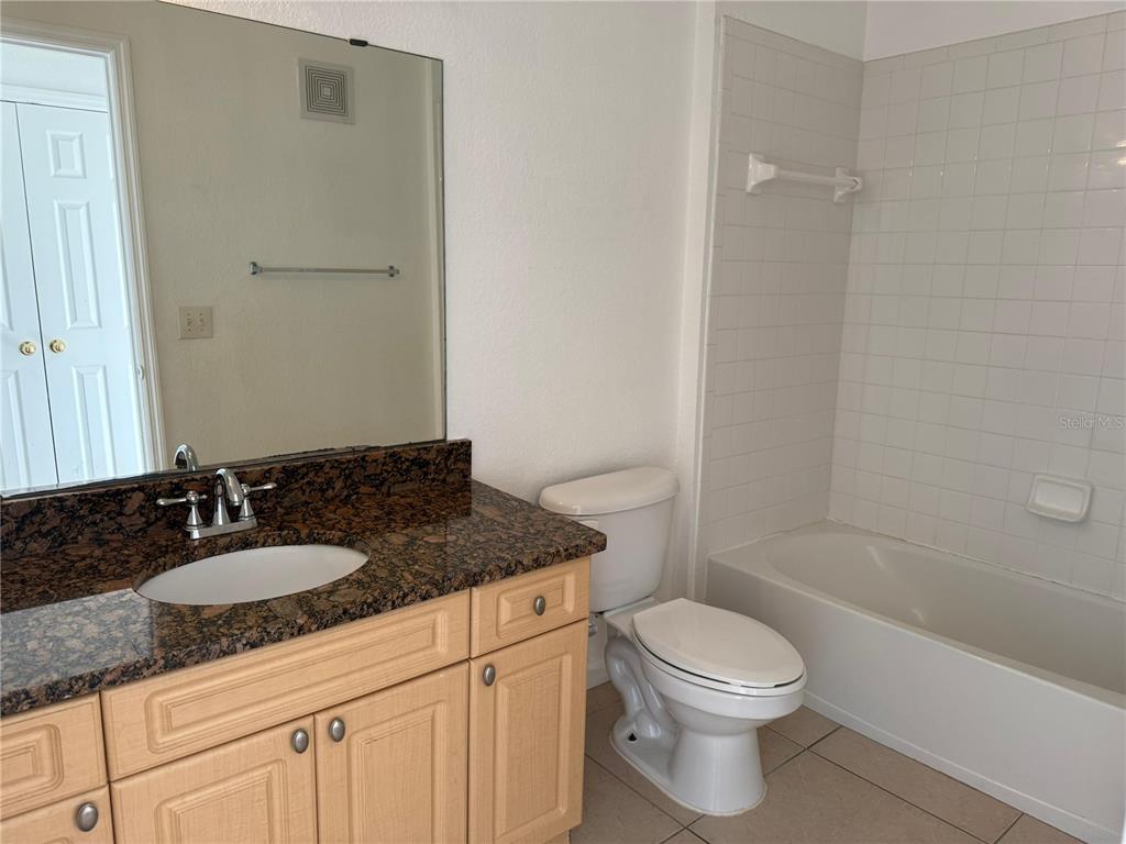3707 Conroy Road, Unit 1731 Orlando, FL 32839 - Photo 29 of 40 a bathroom with a granite countertop sink toilet and shower