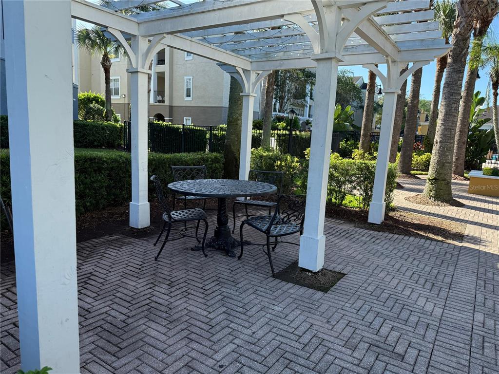 3707 Conroy Road, Unit 1731 Orlando, FL 32839 - Photo 31 of 40 a view of a patio with table and chairs potted plants and floor to ceiling window