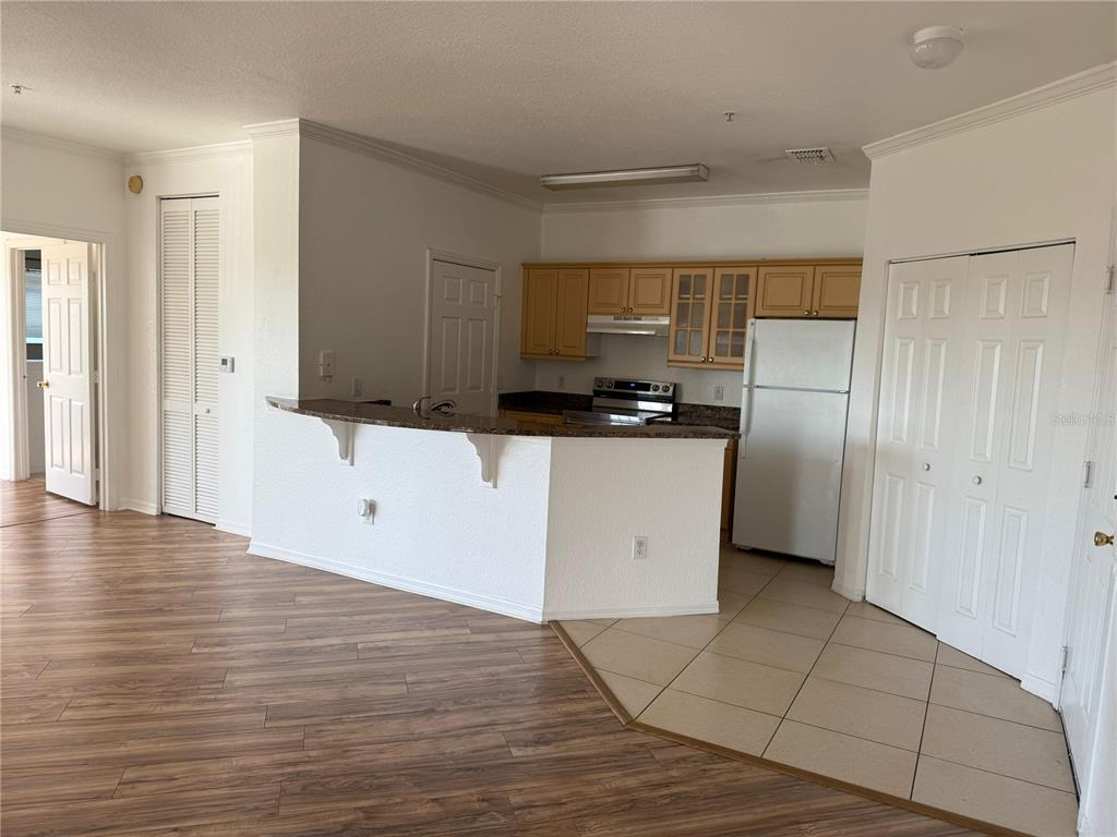 3707 Conroy Road, Unit 1731 Orlando, FL 32839 - Photo 4 of 40 a kitchen with granite countertop a refrigerator and a stove top oven