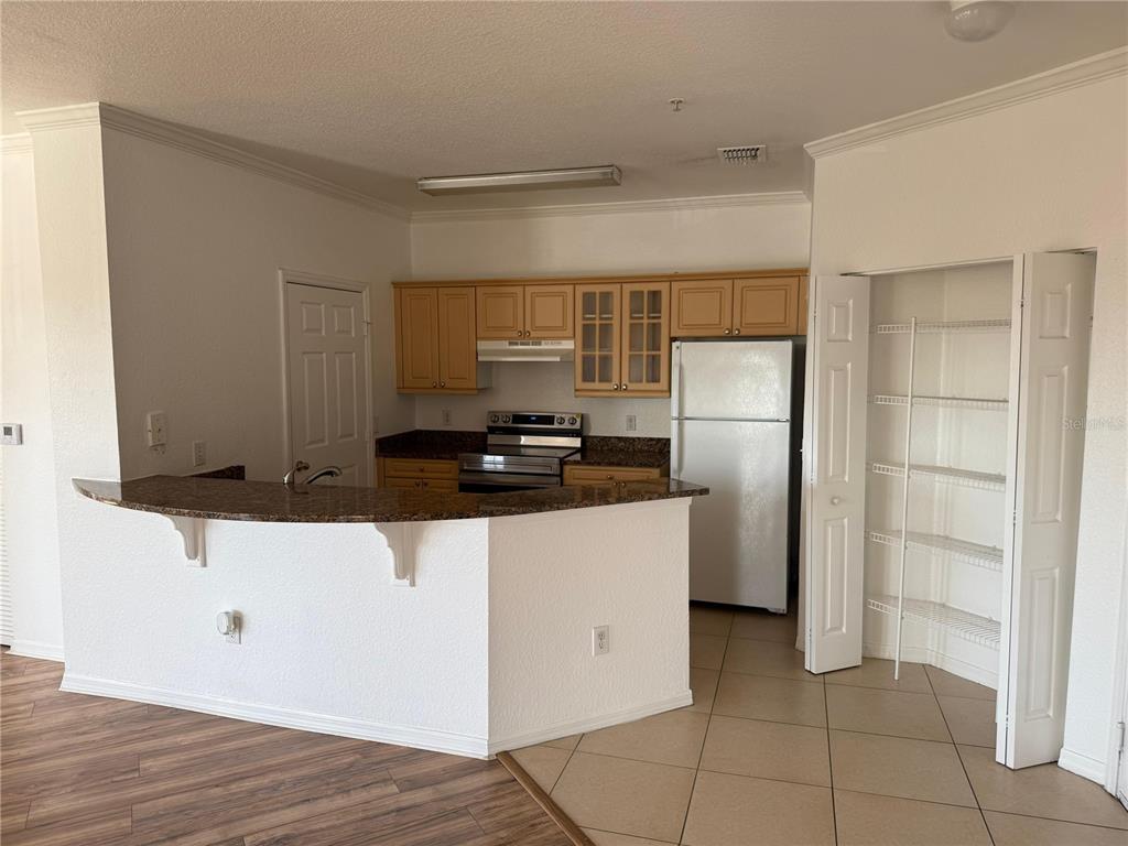 3707 Conroy Road, Unit 1731 Orlando, FL 32839 - Photo 5 of 40 a kitchen with a refrigerator and a stove top oven