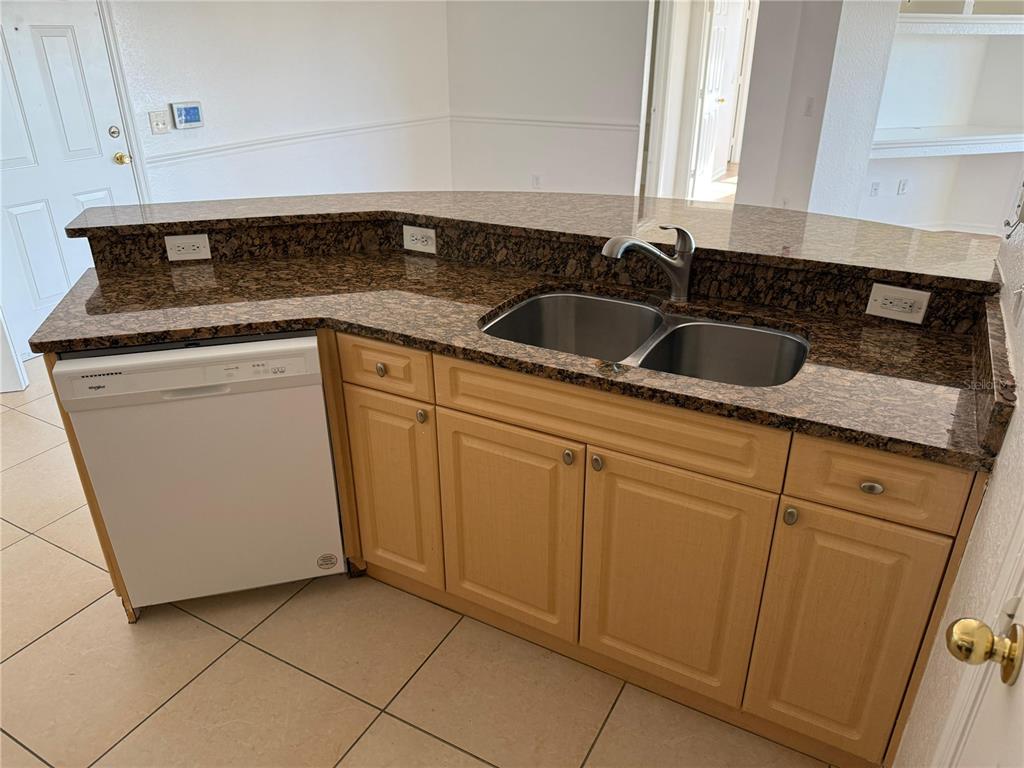 3707 Conroy Road, Unit 1731 Orlando, FL 32839 - Photo 7 of 40 a kitchen with white cabinets sink and white stainless steel appliances