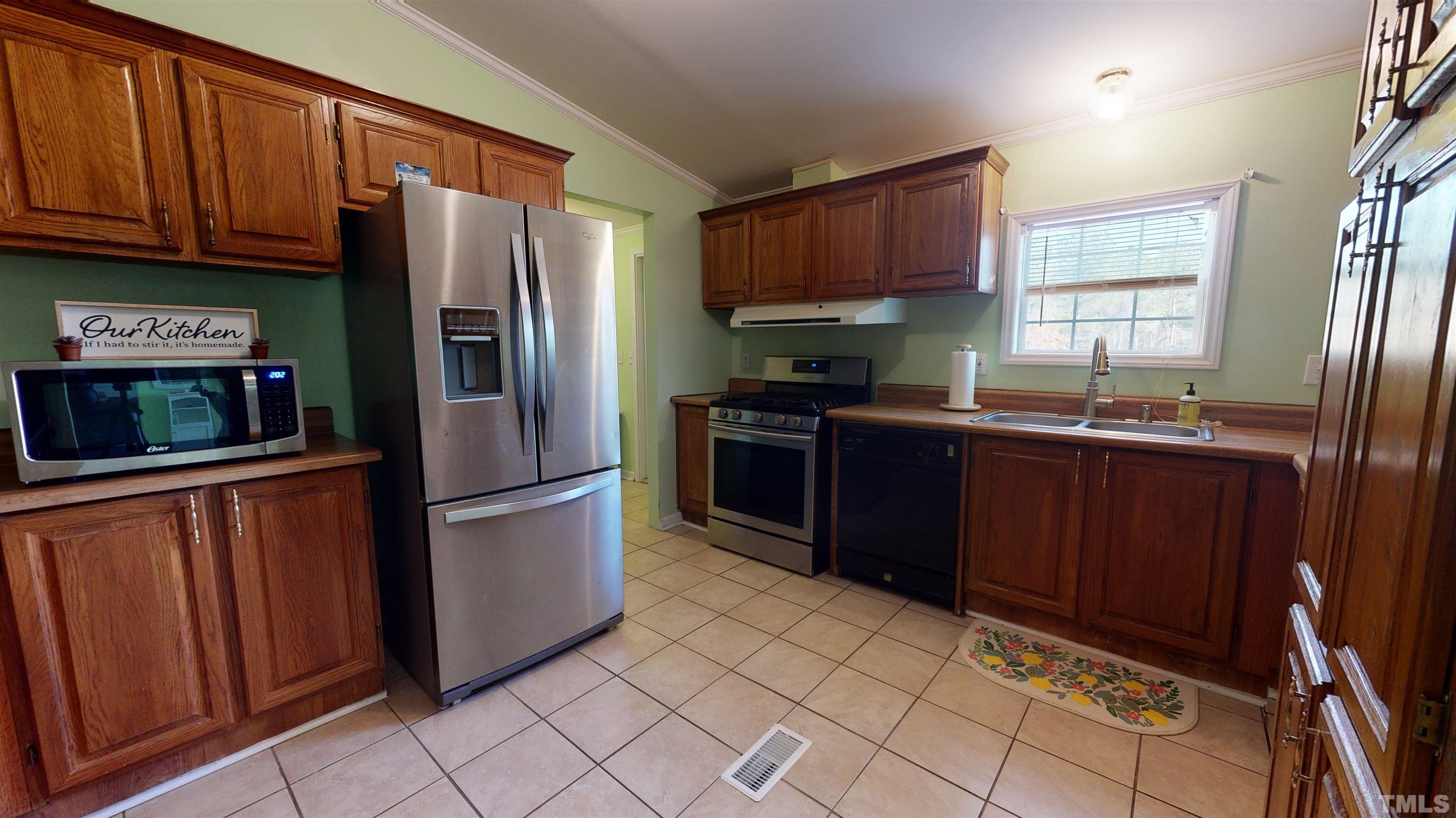 1229 Tingen Road Broadway, NC 27505 - Photo 7 of 17 a kitchen with stainless steel appliances granite countertop a refrigerator stove top oven and sink