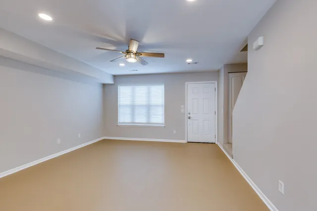 an empty room with a window and a ceiling fan