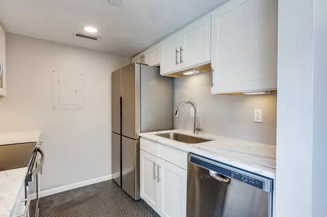 a kitchen with stainless steel appliances granite countertop a sink a refrigerator and a stove