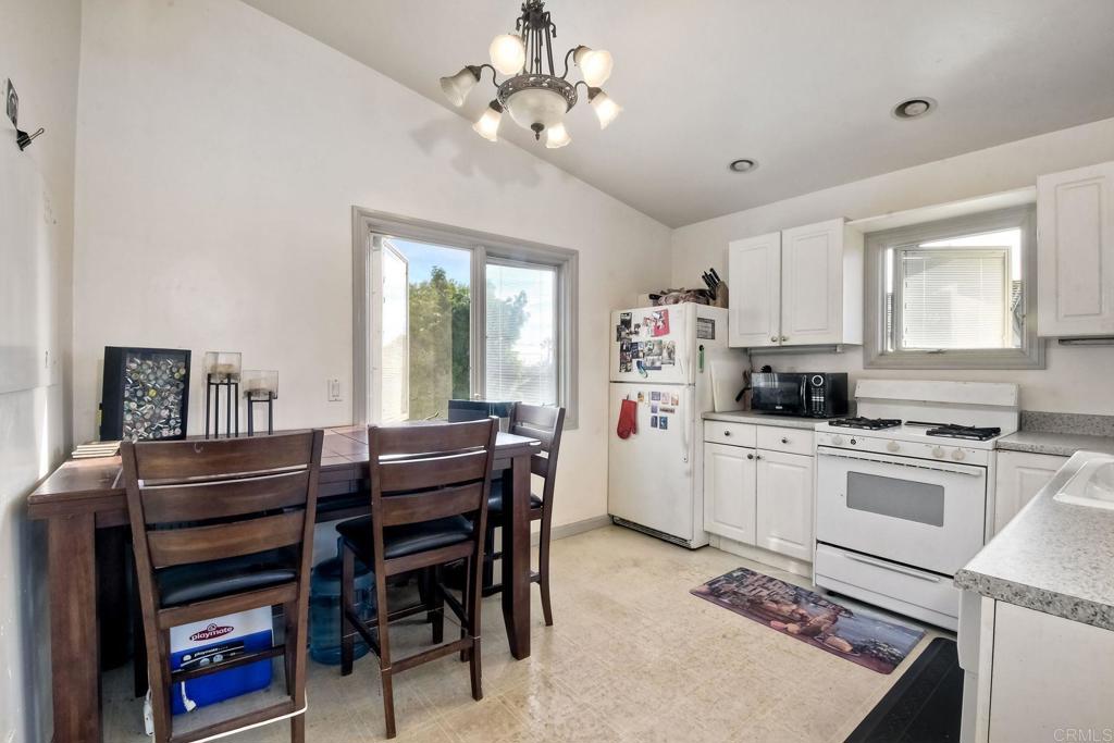 1328 Pine Avenue Carlsbad, CA 92008 - Photo 30 of 48 a kitchen with a dining table cabinets appliances and a window