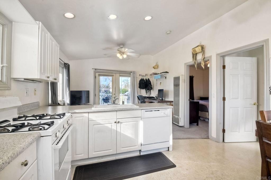 1328 Pine Avenue Carlsbad, CA 92008 - Photo 31 of 48 a large white kitchen with stainless steel appliances granite countertop a stove and a refrigerator