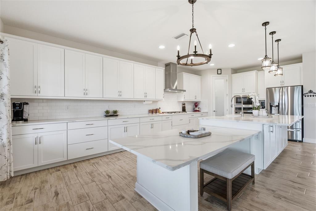12970 Steed Trce Loop Lithia, FL 33547 - Photo 12 of 57 a kitchen with stainless steel appliances granite countertop a sink stove and white cabinets with wooden floor