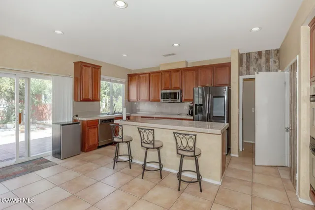a kitchen with stainless steel appliances granite countertop a refrigerator and a stove top oven