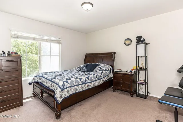 a bed sitting in a bedroom next to a window