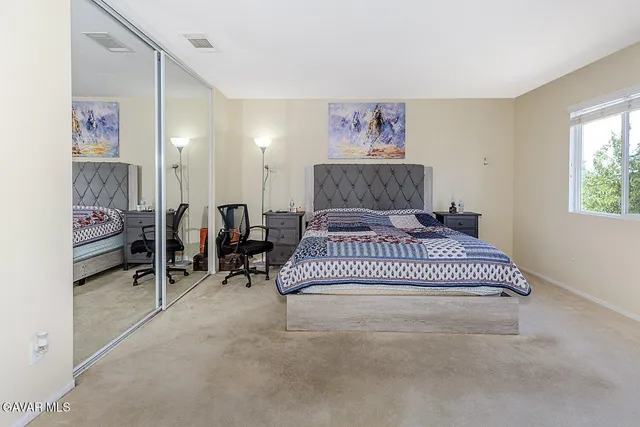 a spacious bedroom with a bed and a cabinets