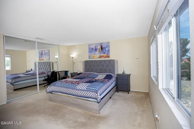 a living room with a bed furniture and a large window