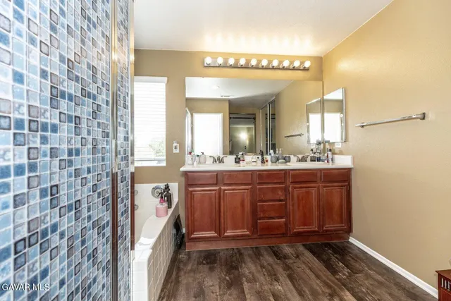 a bathroom with a sink a mirror and a shower