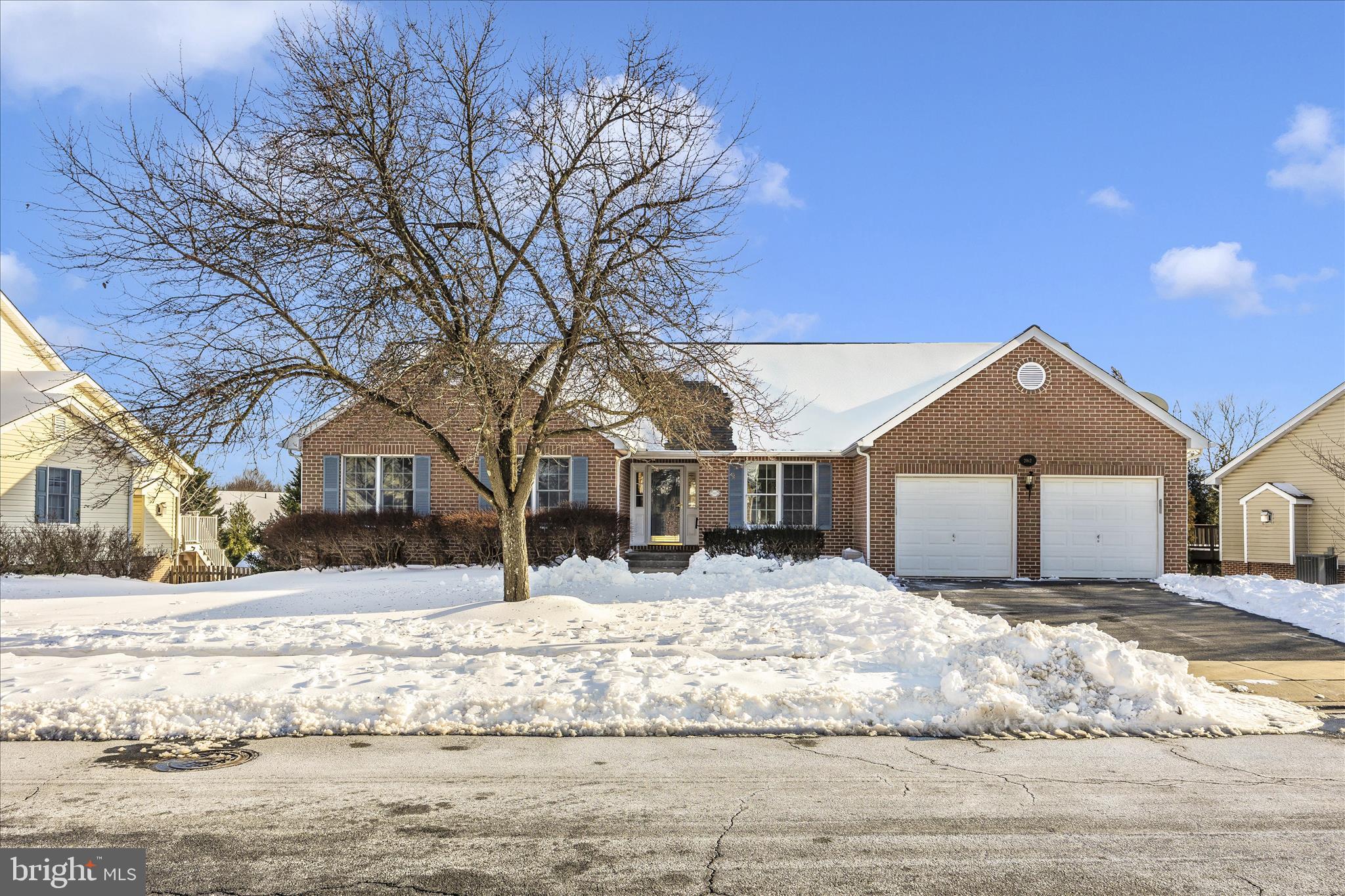 a front view of a house with a yard covered in snow