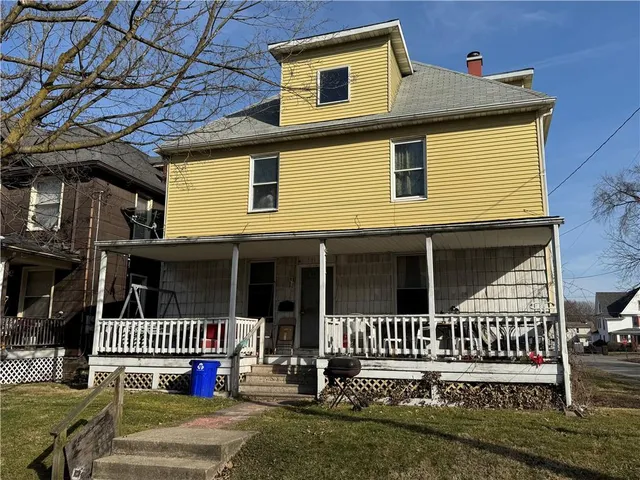 a view of a house with a small yard and wooden fence