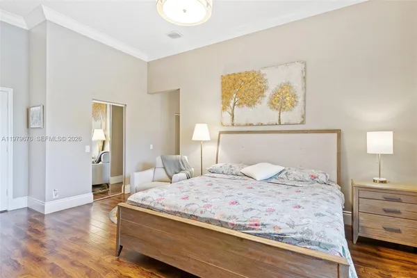a bedroom with a large bed and wooden floor
