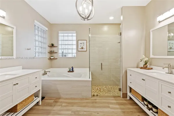 a bathroom with a double vanity sink mirror and bathtub